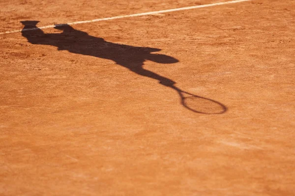 Abstract silhouette or a shadow of an anonymous tennis player serving