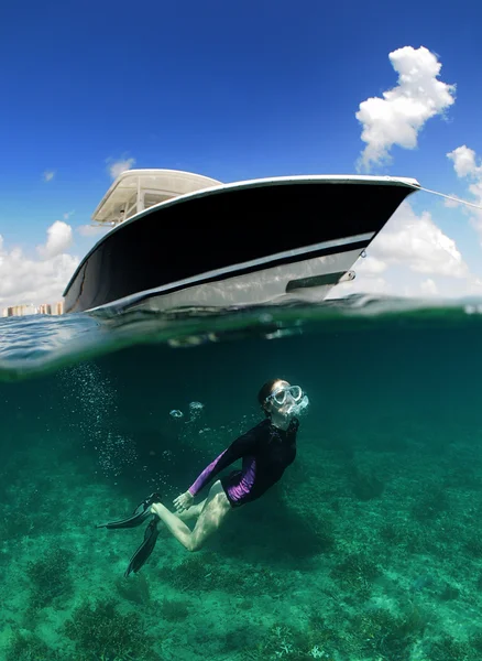 Immagine subacquea di donna che fa snorkeling vicino alla barca — Foto Stock