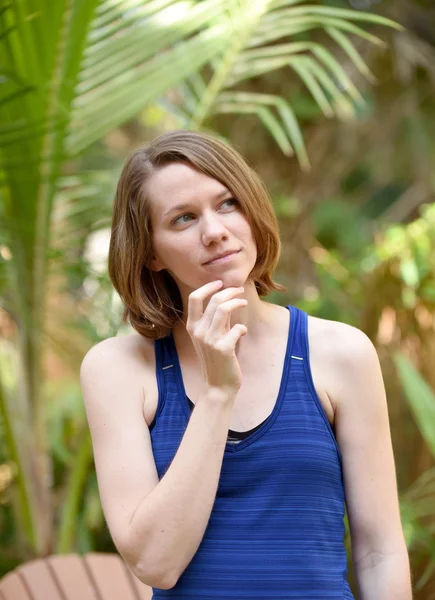 Frau denkt mit der Hand am Kinn — Stockfoto