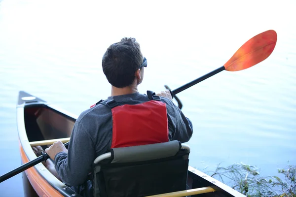 Uomo in kayak indossa occhiali da sole guardando fuori in lontananza — Foto Stock
