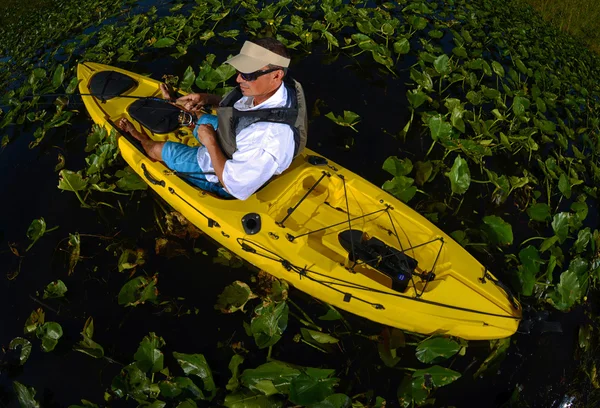 Homem caiaque pesca em almofadas de lírio — Fotografia de Stock