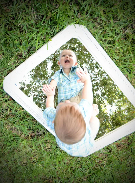 Ung baby tittar själv i spegeln medan leende — Stockfoto