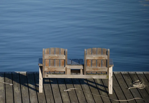 Empty bench overlooking the water in calm, tranquil scene — Stock Photo, Image