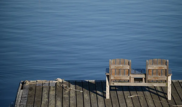 Leeg bankje met uitzicht op het water in een ontspannende scène — Stockfoto