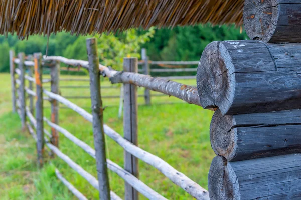 Teil des Holzes des Bauernhauses aus Baumstämmen und Zaun — Stockfoto