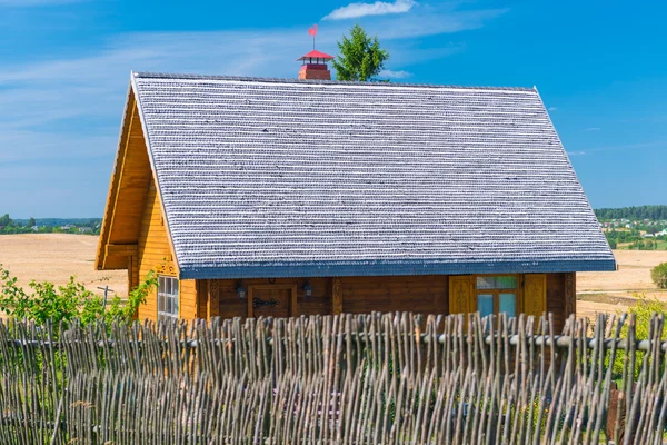 Maison en bois avec une clôture dans le village — Photo