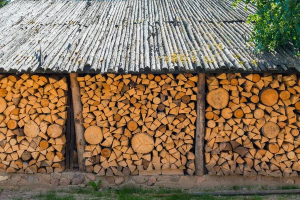 Barn with a wood reserve in the village — Stock Photo, Image