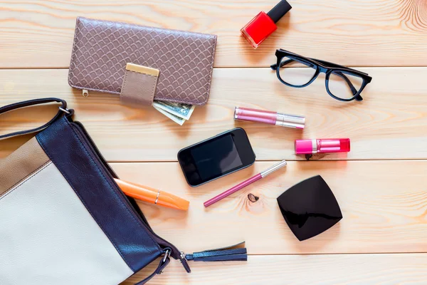 El contenido de los bolsos de las mujeres están dispersos en el suelo —  Fotos de Stock