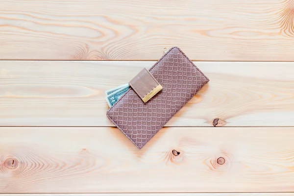 Женский бумажник с деньгами, лежащий на деревянном полу. — стоковое фото