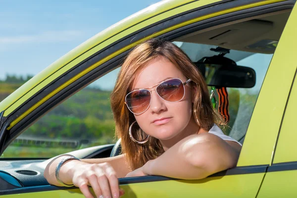 Portrait of a young girl in his car looking out the window — Stock Photo, Image