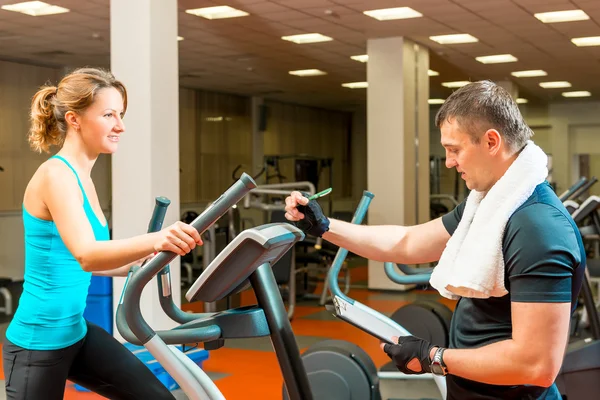 Trainer escribe el resultado a los atletas que entrenan en el gimnasio —  Fotos de Stock