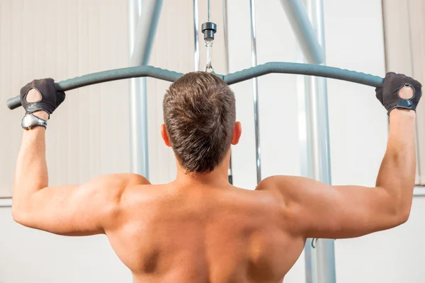 Мускулистый мужчина с голой спиной в спортзале — стоковое фото