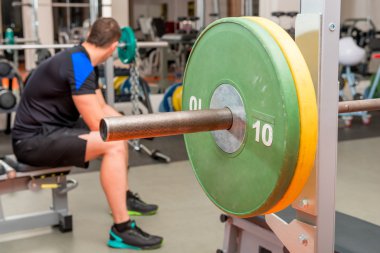 yorgun atlet spor salonunda bir bankta oturan