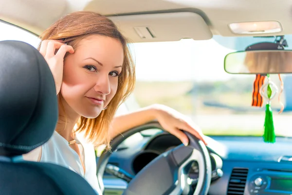 The driver holds hand on the steering wheel and looking back — Stock Photo, Image