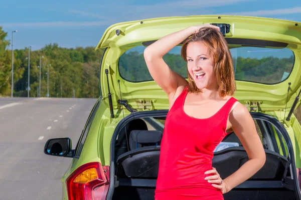 Portrait of a beautiful young woman standing near the car — Stock Photo, Image