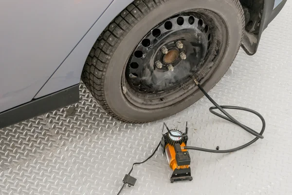 Automatische lenspomp opgeblazen de het wiel in garage — Stockfoto