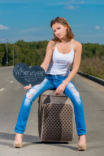 Πορτρέτο του μια όμορφη κοπέλα που κάνει ωτοστόπ με τις αποσκευές — Φωτογραφία Αρχείου