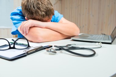 yorgun doktor masada çalışma saatleri içinde ofiste uyur