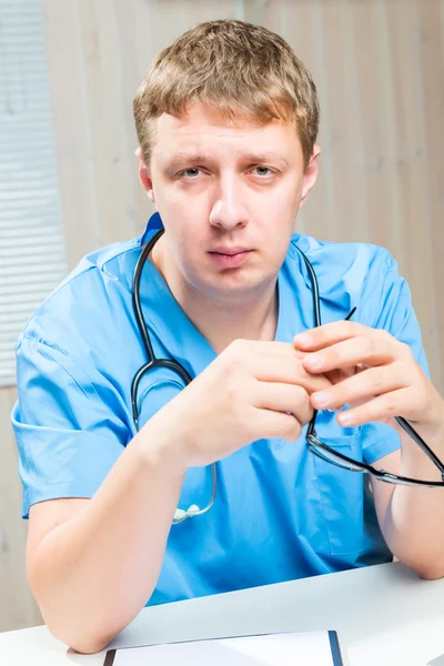 Vertical portrait of a tired doctor in blue uniform — Stock Photo, Image