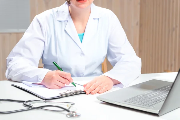 Kobiety w biały płaszcz lekarz pracuje przy biurku w biurze — Zdjęcie stockowe