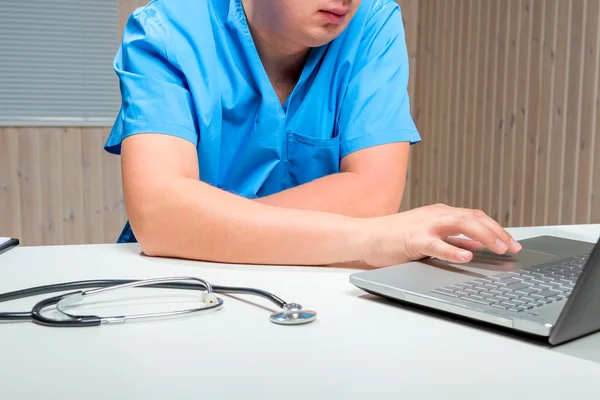 Doutor trabalhando no laptop no hospital do escritório — Fotografia de Stock