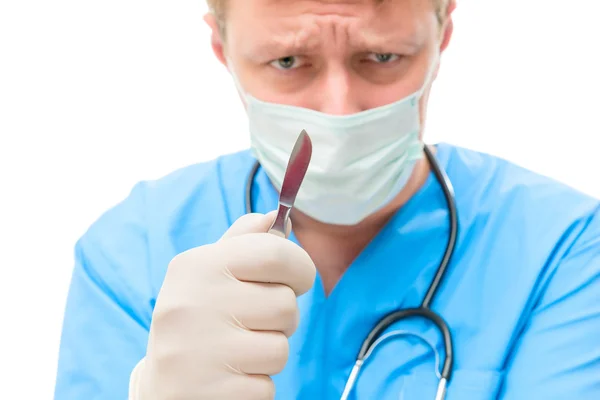 Stressful concentrating surgeon with a scalpel face out of focus — Stock Photo, Image