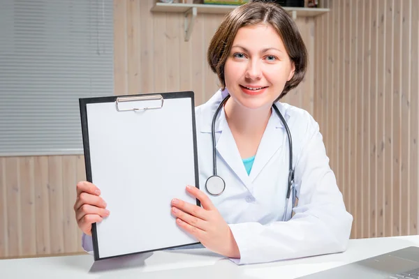 Doctor keeps a clean sheet of paper for an inscription — Stock Photo, Image