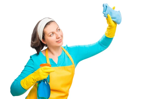 Giovane casalinga pulisce qualcosa su uno sfondo bianco — Foto Stock