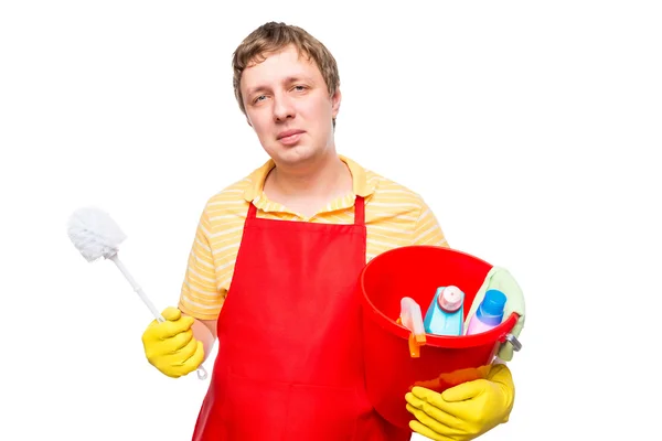 Smiling man in an apron holding a bucket with cleaning agents on — Stock Photo, Image