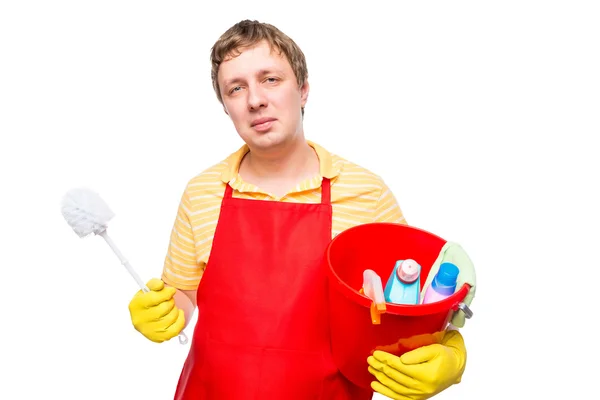 Lächelnder Mann in Schürze, der einen Eimer mit Putzmitteln in der Hand hält — Stockfoto