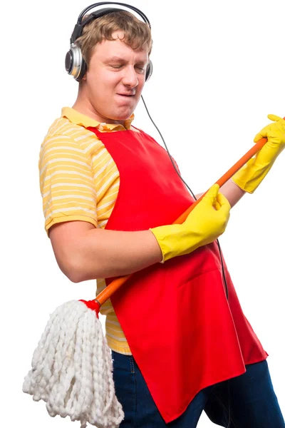 Emotional man housewife with a mop in headphones on a white back — Stock Photo, Image