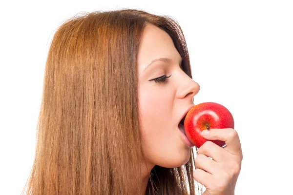 Hezká holka kouše zralé jablíčko červené na bílém pozadí — Stock fotografie