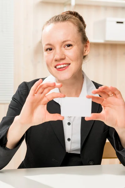 Happy boss with a business card in his hand in the office — Stock Photo, Image