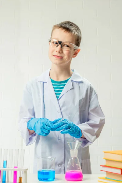 一个男孩在试管中学习多种颜色的物质 进行实验 白色背景的肖像 化验室中的头孢病毒研究概念 — 图库照片