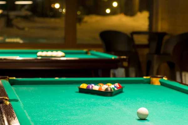 Sports game of billiards on a green cloth. Multi-colored billiard balls with numbers on a pool table