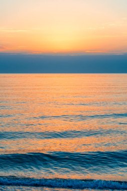 Deniz manzarasında turuncu gün batımının manzarası