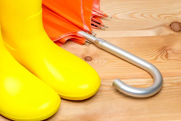 Ein Paar Gelbe Regenstiefel Und Orangefarbener Regenschirm Stockbild