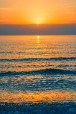 Deniz manzarasında turuncu gün batımının manzarası