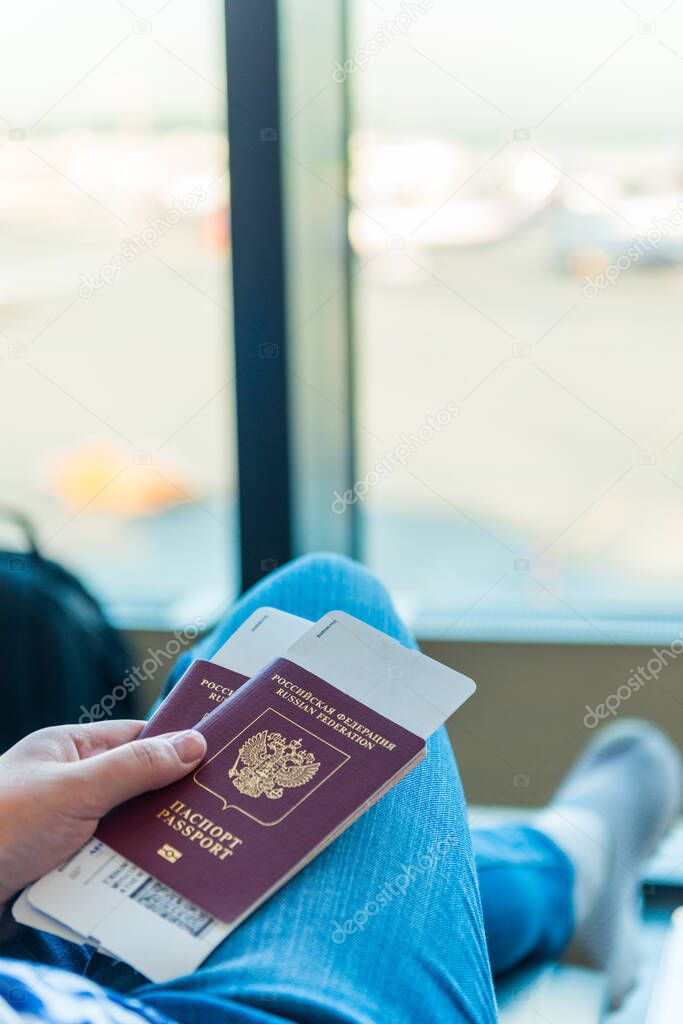 Closeup of female holding passports and boarding pass at airport