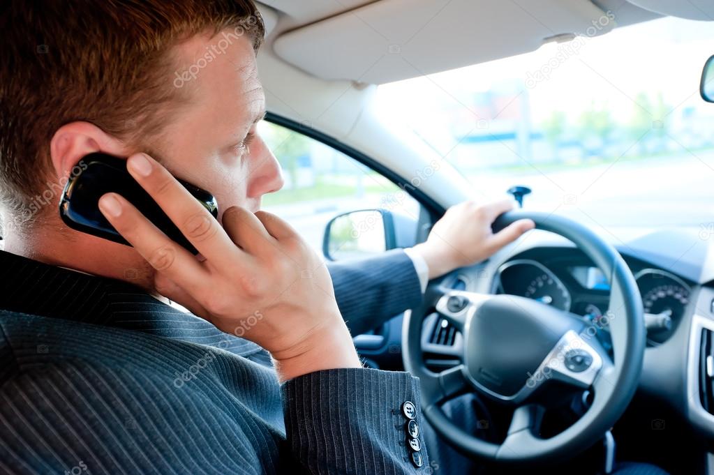 male businessman talking on a cell phone while driving