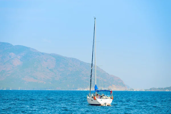 Enda båt med deflateras segel i fjärden av havet — Stockfoto