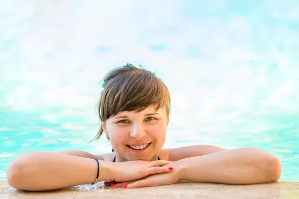 Retrato de uma menina alegre e bonita na água da piscina — Fotografia de Stock