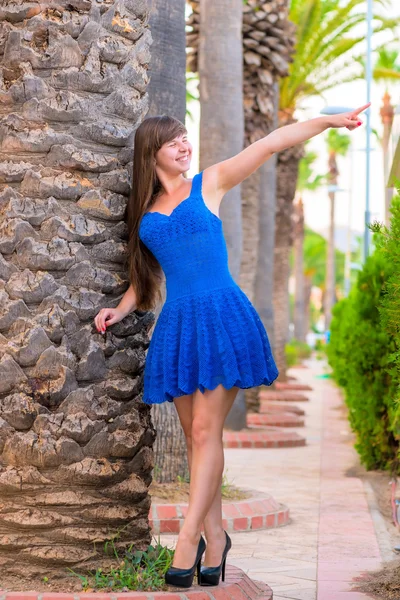 Young girl in a blue dress is pointing in the direction — Stock Photo, Image