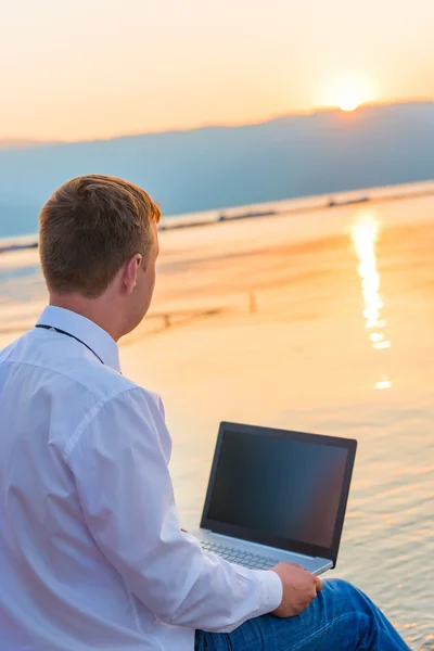 Uomo d'affari di successo sulla spiaggia con un computer portatile — Foto Stock
