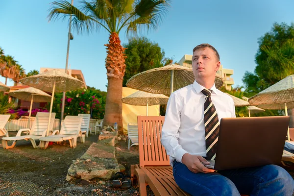 Manažer v košili a kravatě na pláži na lehátko — Stock fotografie