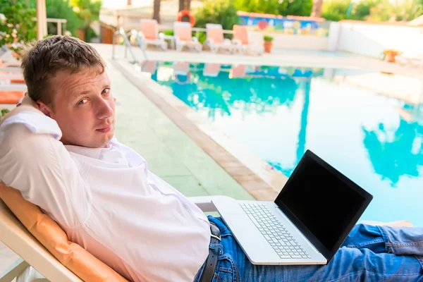 Joven hombre de negocios guapo está descansando cerca de la piscina — Foto de Stock