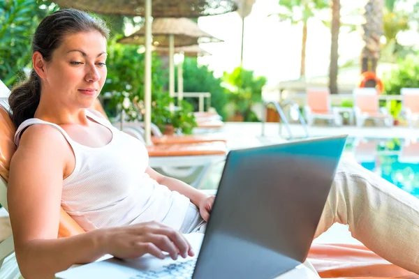 Mujer en una camiseta blanca con un ordenador portátil — Foto de Stock