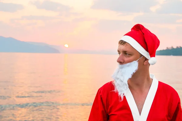 Мужчина в костюме Санта-Клауса на море — стоковое фото