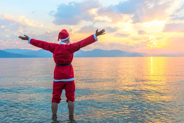 Papai Noel de pé descalço no mar — Fotografia de Stock