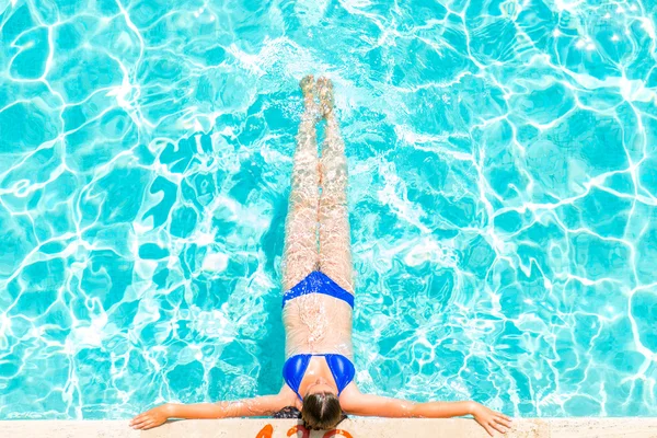 Meisje sunbathes liggen in een pool — Stockfoto